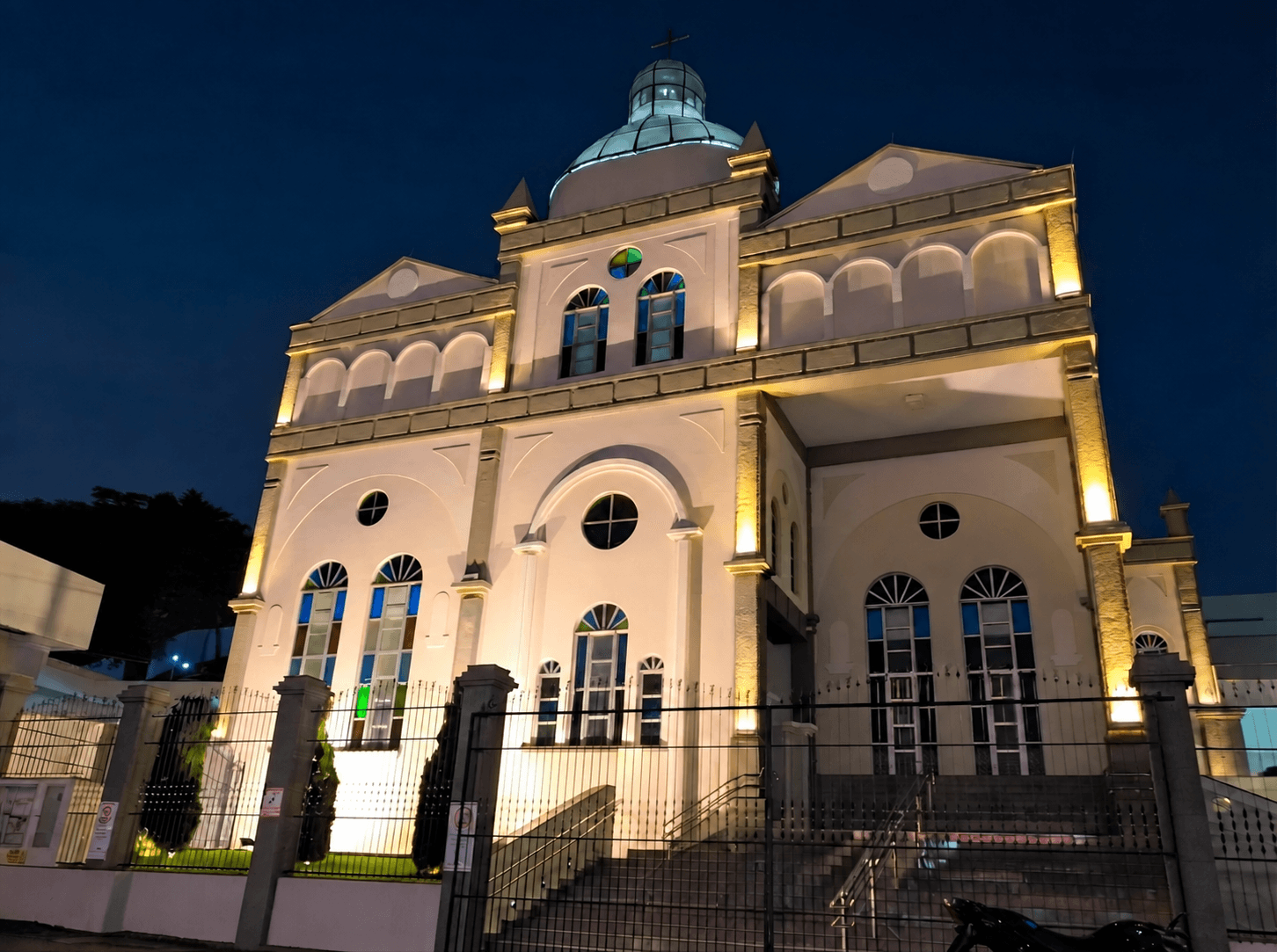Paróquia São Sebastião iluminada à noite, com sua cúpula e cruz